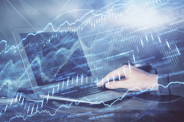 Double exposure of man writing on paper with forex graph. Concept of research and trading.