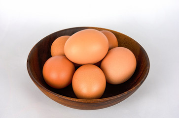 Fresh organic brown eggs in wood bowl isolated in white background with clipping path