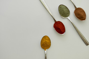 Various colorful spices arranged on spoons