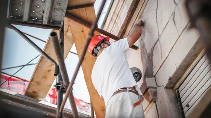 Deurstickers Man worker standing on scaffolding and restore old building facade © guruXOX