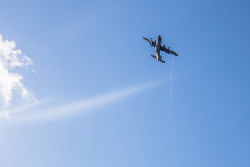 Warplane in training and demonstration cutting blue sky with white clouds