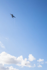 Warplane in training and demonstration cutting blue sky with white clouds