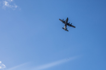 Warplane in training and demonstration cutting blue sky with white clouds