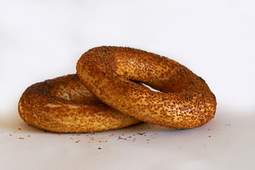 Two sesame bagels (crispy) on a white background.