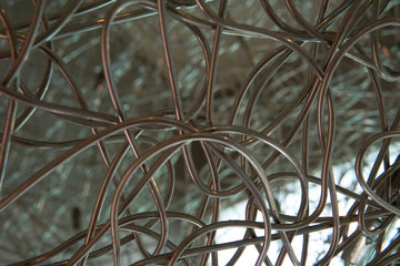 Brown color synthetic rattan like metal shaped overlapping in curvy lines to make for a beautiful decoration object.