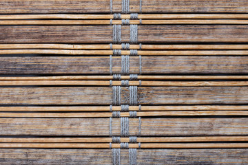 Textures and patterns close up concept. Detailed closeup of brown wood panels with braided strings