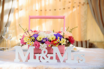 Beautifully decorated wedding table with flowers and MR&MRS letters