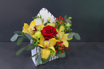 Sensual floral arrangement of exotic flowers in a box - an envelope on a dark background