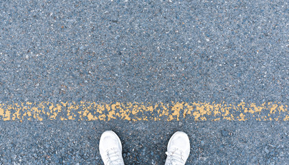 Top-view runner feet on asphalt road lines for background