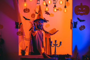 Funny wise wizard on a Halloween background. Wizard, sorcerer, warlock. Mystery and horror concept....