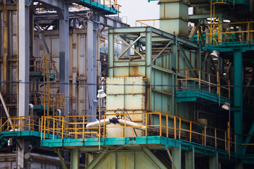 Parts of the refinery, refining oil into gasoline, kerosene, engine oil, construction in the daytime against the background of continuous clouds, technological landscape