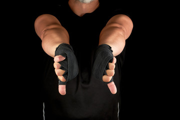 adult athlete in black uniform and hands rewound with textile bandage