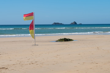 red and yellow lifeguard flag on the beach