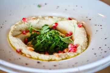 lebanese hummus dish with fresh vegetables, beef meat & pomegranate seeds