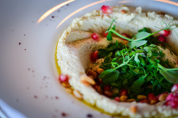 lebanese hummus dish with fresh vegetables, beef meat & pomegranate seeds