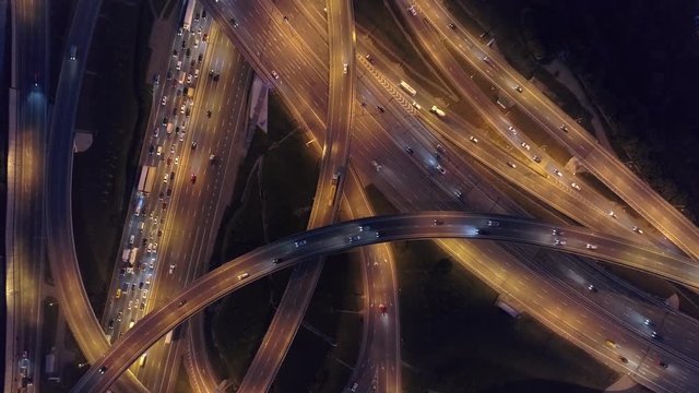 Aerial top down beautiful multi-level junction night multi-lane road pattern. Moscow Russia roundabout. Active traffic many cars jam. Cinematic night illumination. Road construction complex. Logistics