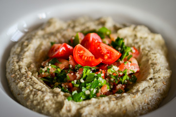 lebanese hummus dish with fresh vegetables, beef meat & pomegranate seeds