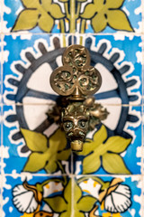 old modernist faucet in the form of a dragon and tiled with flowers