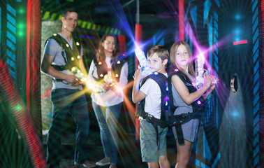 Obraz na płótnie Canvas Kids standing back to back on beams with laser pistols