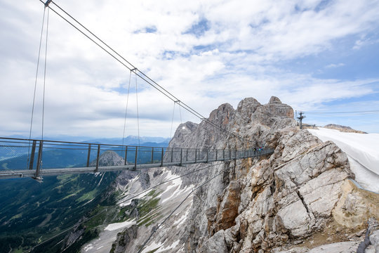 Metal footbridge over mountain peaks in Austria.