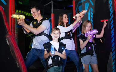 Obraz na płótnie Canvas Parents and children playing laser tag