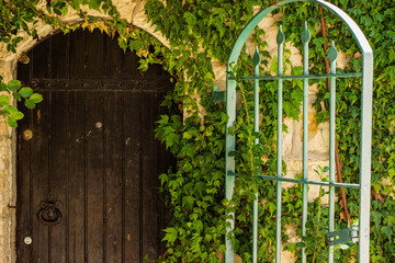 rustic country side European garden building exterior space arch shape wooden door iron gate and...