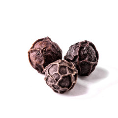 three balls of black pepper on a white background isolated close-up