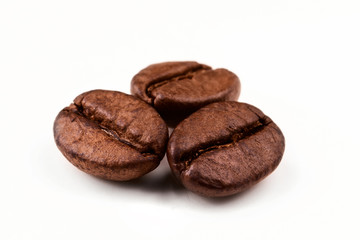 three coffee beans on a white isolated background close-up