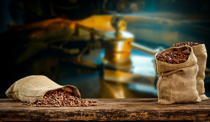 Coffee beans in jute sacks with blurrred coffee machine view