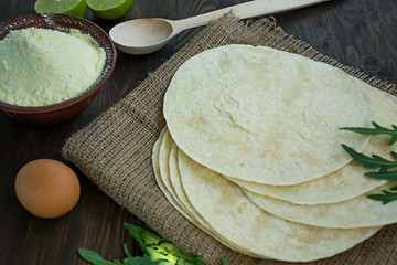 Flat cakes for tacos or burritos. Pita bread for making tacos. Dark wooden background.