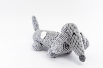 Gray dog (dachshund), knitted toy. Isolated on white background