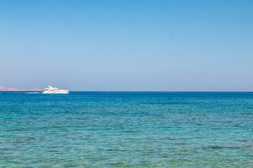 Boat sailing far at the open sea. Yacht at sea. Luxury summer adventure, active vacation in Mediterranean sea.