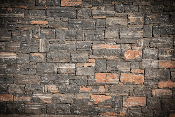 Texture of a stone. Old stone wall texture background. Grey stone wall as a background or texture. Stone wall of natural stones in different sizes. Side covering with natural stones.