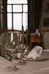 A glass on the table for wine. Interior of a classic restaurant in an old castle. Traveling in Europe. Served tables and antiquity.