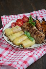 Grilled chicken fillet with baked vegetables. Wooden background.