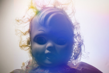scary old doll illuminated from behind