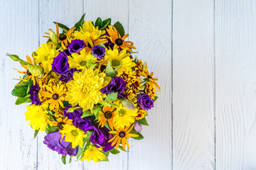 close - up of colorful beautiful spring bouquet isolated on white wooden background. Bright purple and yellow flowers. Decorative composition for the holiday mother's day and birthday. Copy space