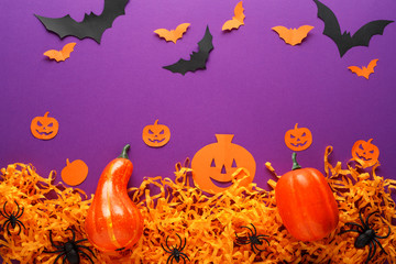 Obraz na płótnie Canvas Halloween decorations with pumpkins, spiders, bats, paper Jack O'Lantern on the purple background.Happy Halloween concept.