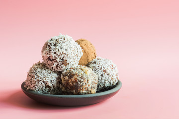 Homemade energy dates balls on pink background. Space for text.