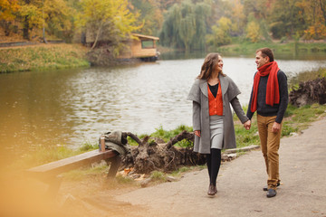 couple on autumn walk outdoors. Two lovers in autumn park. Love and tender touch