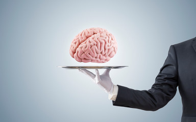 Businessman offering human brain on silver tray 