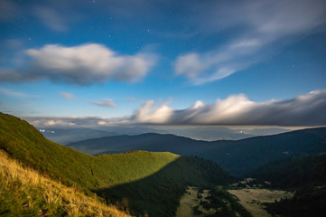 Panorama of the starry sky over the foggy mountains