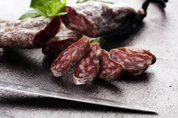 salami cut. thinly sliced salami on a wooden texture on the background.