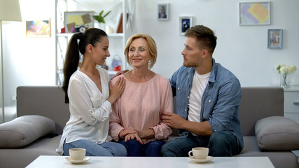 Fototapeta premium Couple embracing mother-in-law, relationship of trust and love, understanding