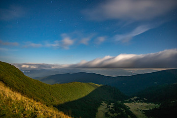 Panorama of the starry sky over the foggy mountains