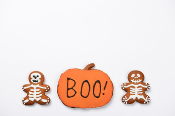 The hand-made eatable gingerbread Halloween sceletons and pumpkin on white background