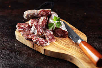 salami cut. thinly sliced salami on a wooden texture on the background.