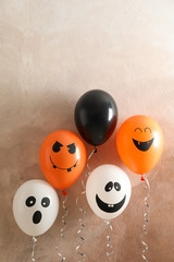 Different balloons on brown background. Halloween concept, space for text