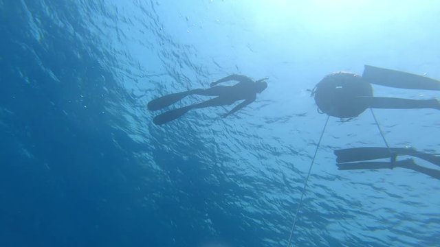 Freedivers ascend along the rope in a sea. Blue Hole, Dahab, Egypt.