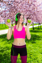 Young female in sportswear with green apple